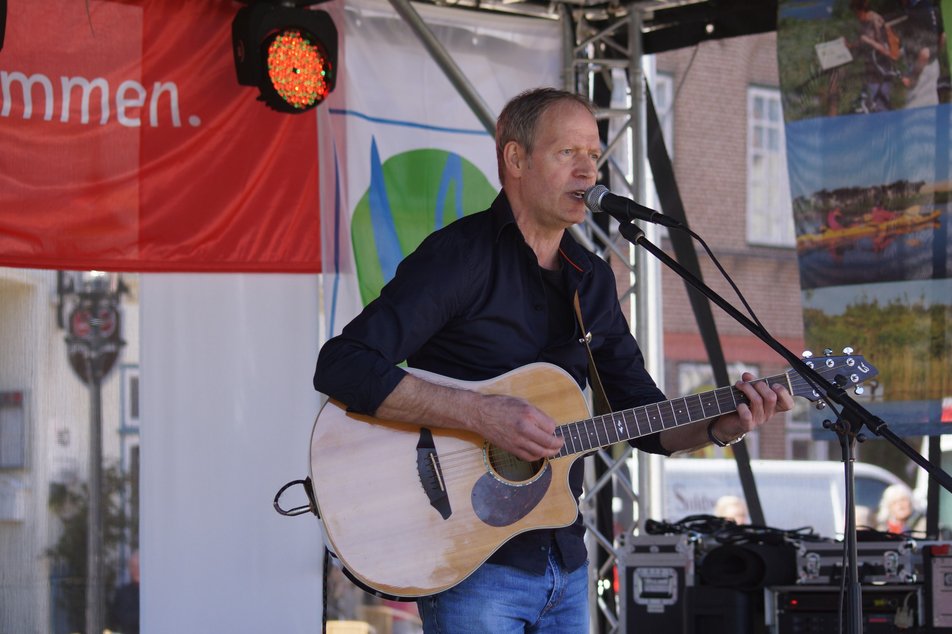 Sänger mit Gitarre auf einer Bühne