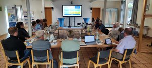 Personen sitzen zusammen an einem Tisch