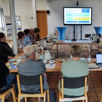 Personen sitzen zusammen an einem Tisch